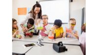 Image of a teacher working on a science project with children.