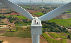 cuacasian man and woman electric engineer discussing for maintenance wind turbine or windmill on the top of wind turbine.Sustainable,renewable,clean energy concept.aerial top view.