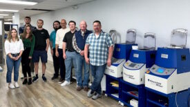 People standing in front of mixers at Hauschild Engineering facility