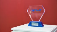 Picture of a clear acrylic award sitting on a stand with a red background